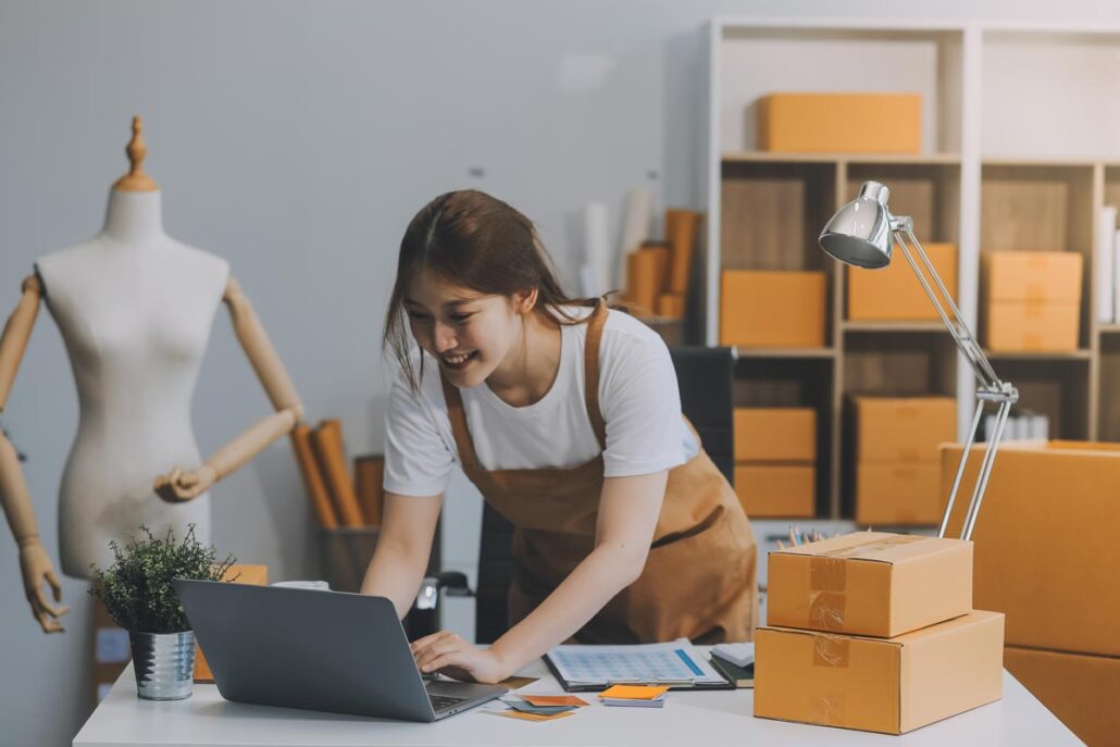 An employee on her laptop around shipping boxes